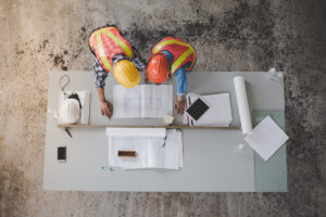 An above view of two construction managers reviewing blueprints in Meridian.